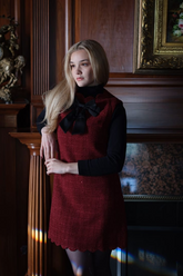 a lady in a black knit top and a red tweed sequin dress